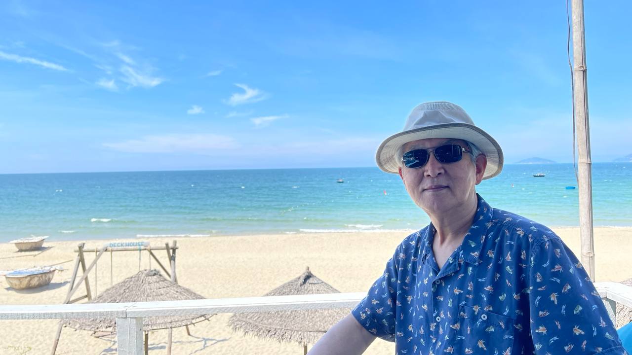 바다를 배경으로 앉아 있는 김광수 작가